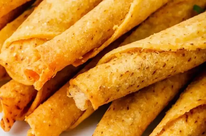 Taquitos que fueron cocinados en una freidora de aire, en un plato